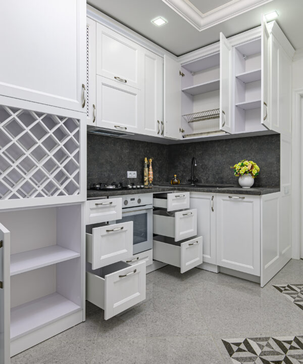 Open doors and drawers at modern black and white woden kitchen in classic style